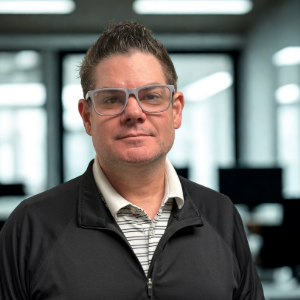 portrait of a man with a business casual shirt with stripes and a collar and a zip up over top