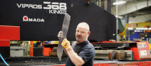 a man holds up a piece of sheet metal